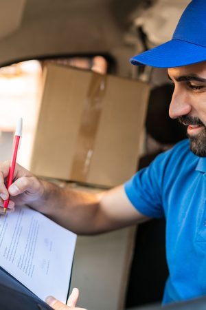 delivery-man-checking-delivery-list-in-van-2021-08-28-11-00-04-utc