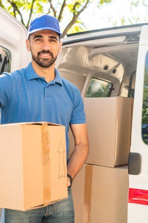 delivery-man-unloading-cardboard-boxes-from-van-2021-08-28-08-44-53-utc